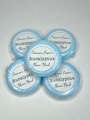 Five eucalyptus scented shower bombs stacked with a label that reads: “Jasmine’s Essence Eucalyptus Shower Bomb”