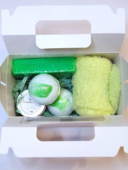 A green bath set including two pedi bombs, a 1oz. body butter, a pumice stone , and cozy socks scented in cucumber melon