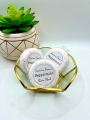 Three white peppermint scented shower bombs in a small decorative dish with a label reading: “Jasmine’s Essence Peppermint Shower Bomb”