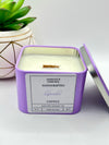 A Lavender Scented candle with a wooden crackle wick in an 8oz. lavender purple square tin with a label that reads: “Jasmine’s Essence Handcrafted Lavender Candle”