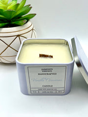 A Vanilla Cinnamon Scented candle with a wooden crackle wick in an 8oz. Pearl white square tin with a label that reads: “Jasmine’s Essence Handcrafted Vanilla Cinnamon Candle”